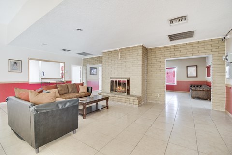 A living room with a grey couch and a fireplace.