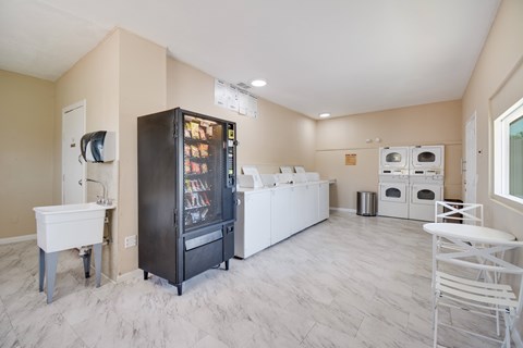 A kitchen with a black fridge and white cabinets.
