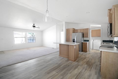 A spacious kitchen with wooden cabinets and a white ceiling.