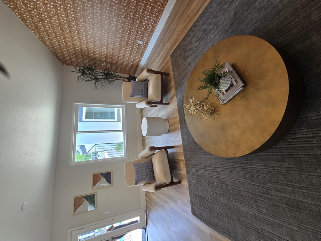 A round wooden table with a plant on top is in the center of the image.