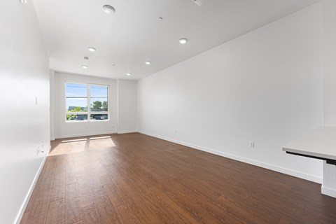 A large empty room with wooden floors and white walls.
