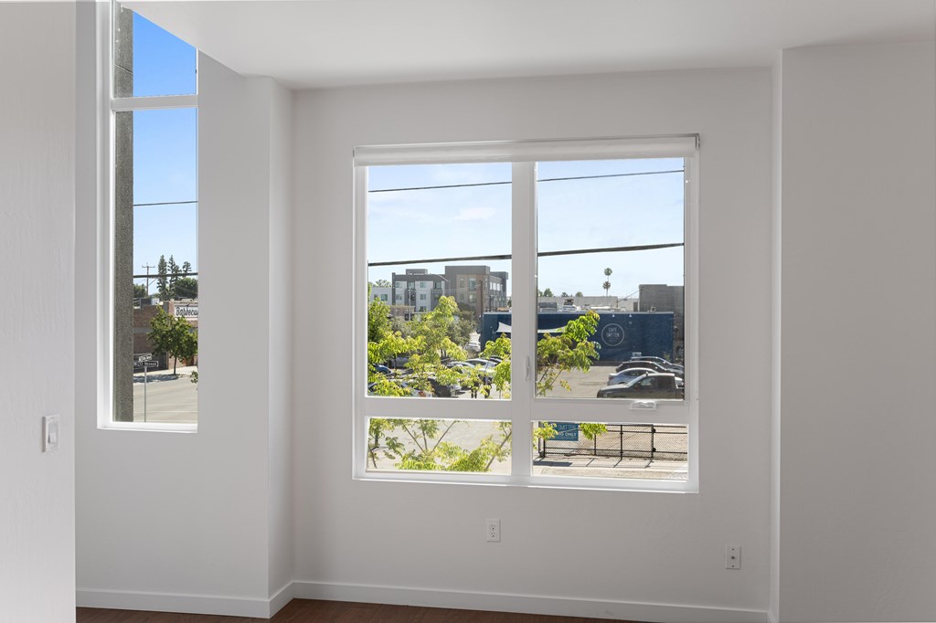 A white room with a large window overlooking a street.