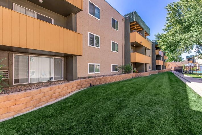 A long building with a green lawn in front.
