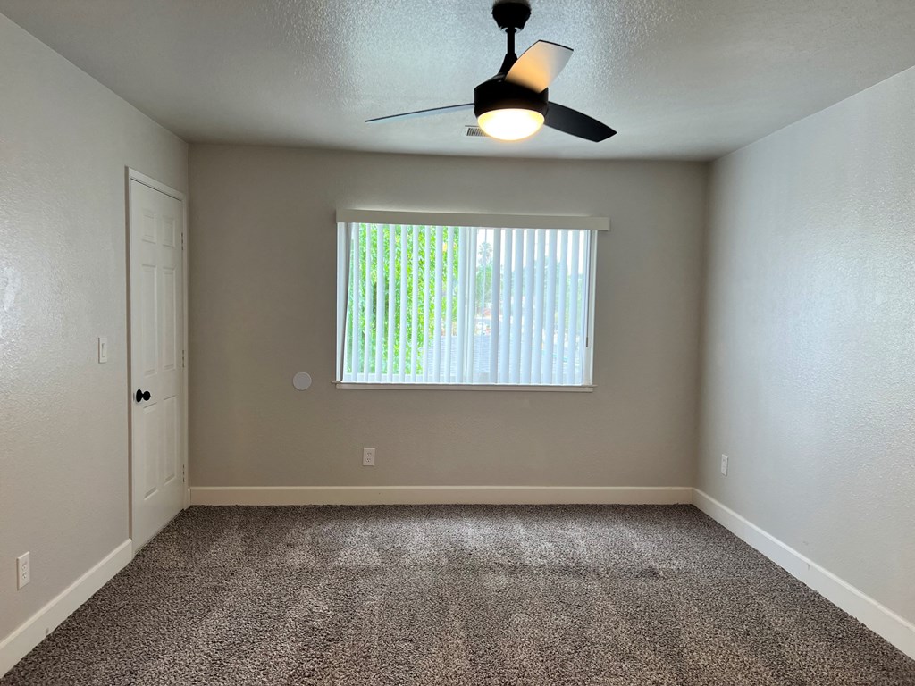 a bedroom with a ceiling fan and a window