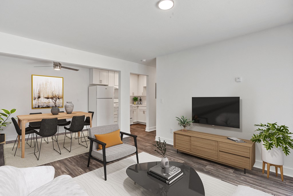 a living room with white walls and a large tv on top of a wooden cabinet