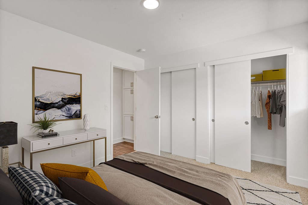 a bedroom with white walls and white closets