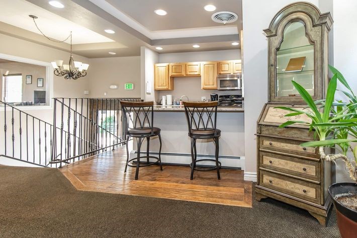 A kitchen with a bar stool and a mirror.