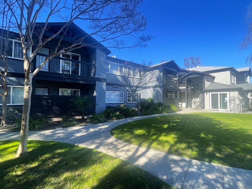 an apartment building with a sidewalk in front of it
