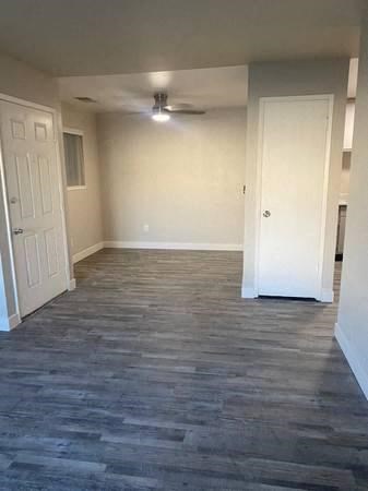 a empty room with a ceiling fan and a door