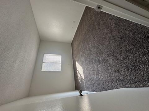 a room with a window and a white wall and a bath tub