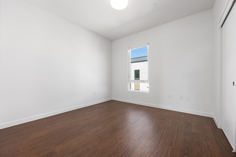 Empty room with wooden floor and white walls.