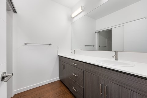 A bathroom with a white counter top and a mirror.