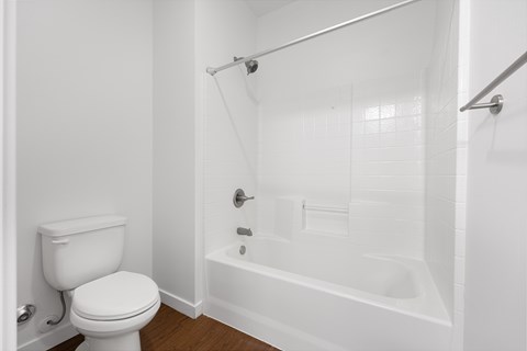 A white toilet is next to a white bathtub in a bathroom.