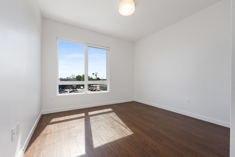 A room with a window overlooking a parking lot.