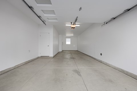 A long, empty hallway with white walls and a concrete floor.