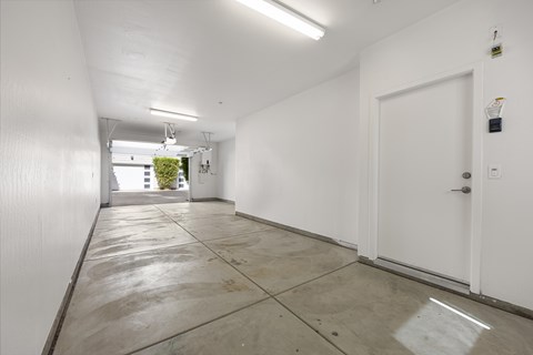 A long white hallway with a door on the right.