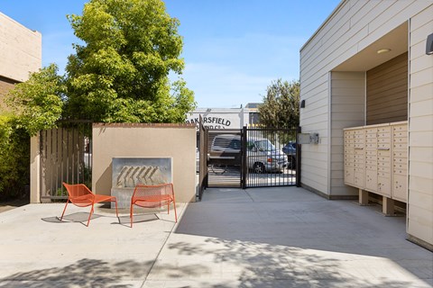 A small courtyard with a bench and a fence.