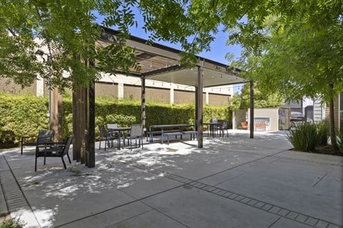 A park with benches and trees in the foreground and a building in the background.