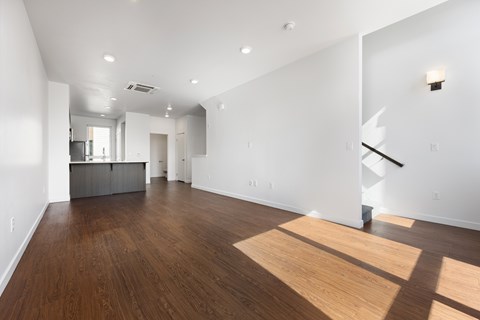 A large empty room with wooden floors and white walls.