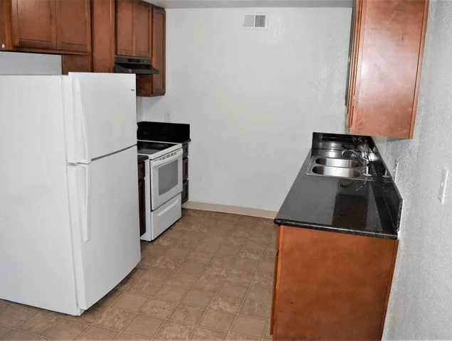 a kitchen with a refrigerator and a stove and a sink