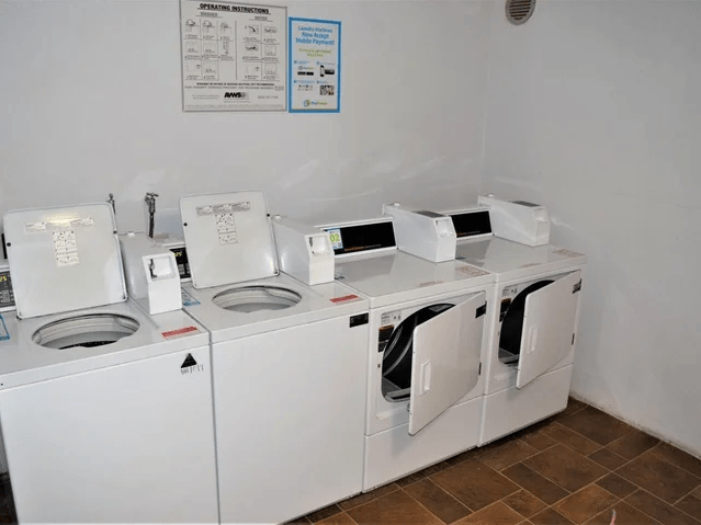 a group of washing machines and dryers in a room