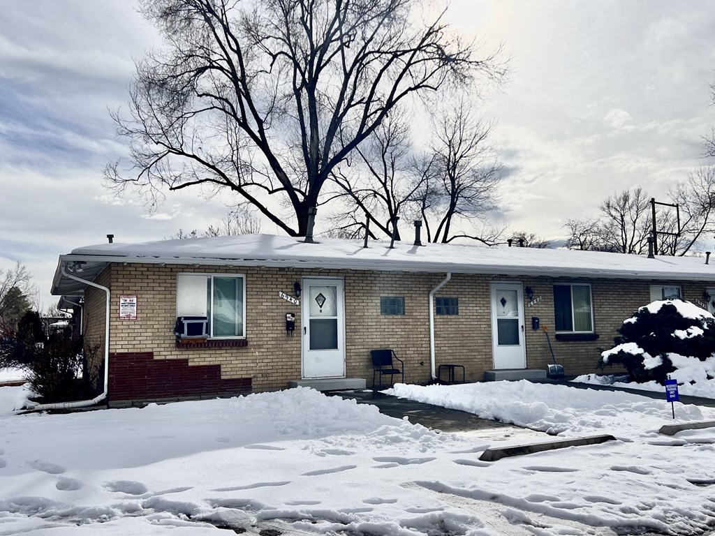 a tan brick house in the snow