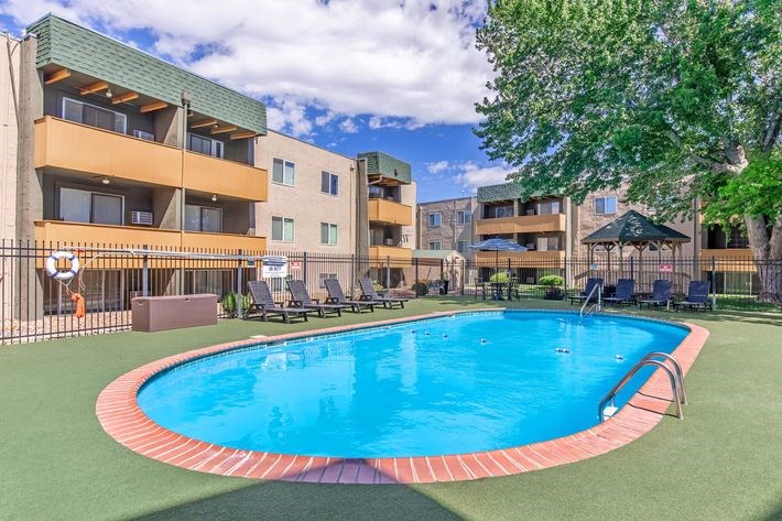 A swimming pool in a courtyard surrounded by apartment buildings.
