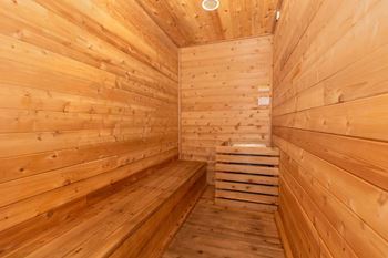 A wooden sauna with a bench in the middle.