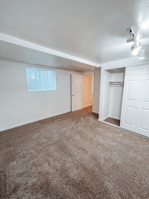 an empty living room with carpet and white walls