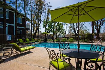 our apartments have a pool and patio with chairs and umbrellas