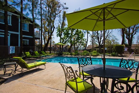 our apartments have a pool and patio with chairs and umbrellas