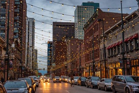 a city street filled with cars and lights on a cloudy day