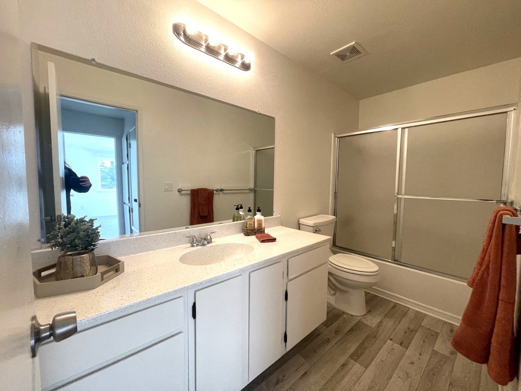 a bathroom with a sink and a shower and a toilet