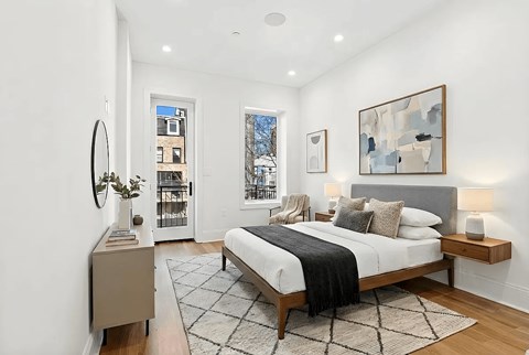 A bedroom with a large bed and a painting on the wall.