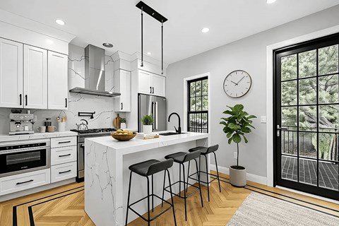 A modern kitchen with white cabinets and a marble island.