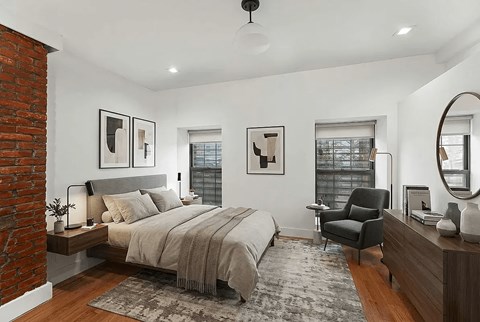 A bedroom with a brick wall and a large bed.