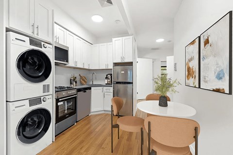 A modern kitchen with a washer and dryer stacked on top of each other.