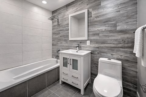 A white bathroom with a wooden wall and a white toilet.