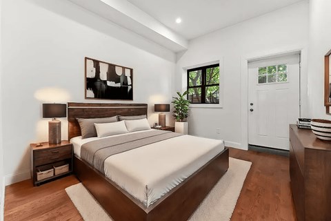A bedroom with a large bed and a painting on the wall.