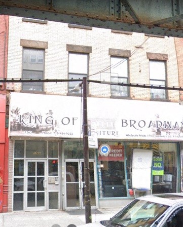 A white car is parked in front of a store.