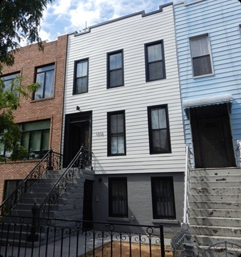 A white building with black windows is in front of a blue building.