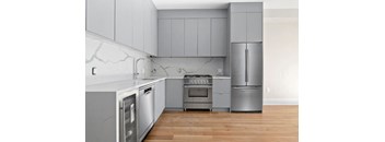 a kitchen with gray cabinets and stainless steel appliances
