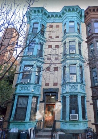 A brown building with a blue building in front of it.