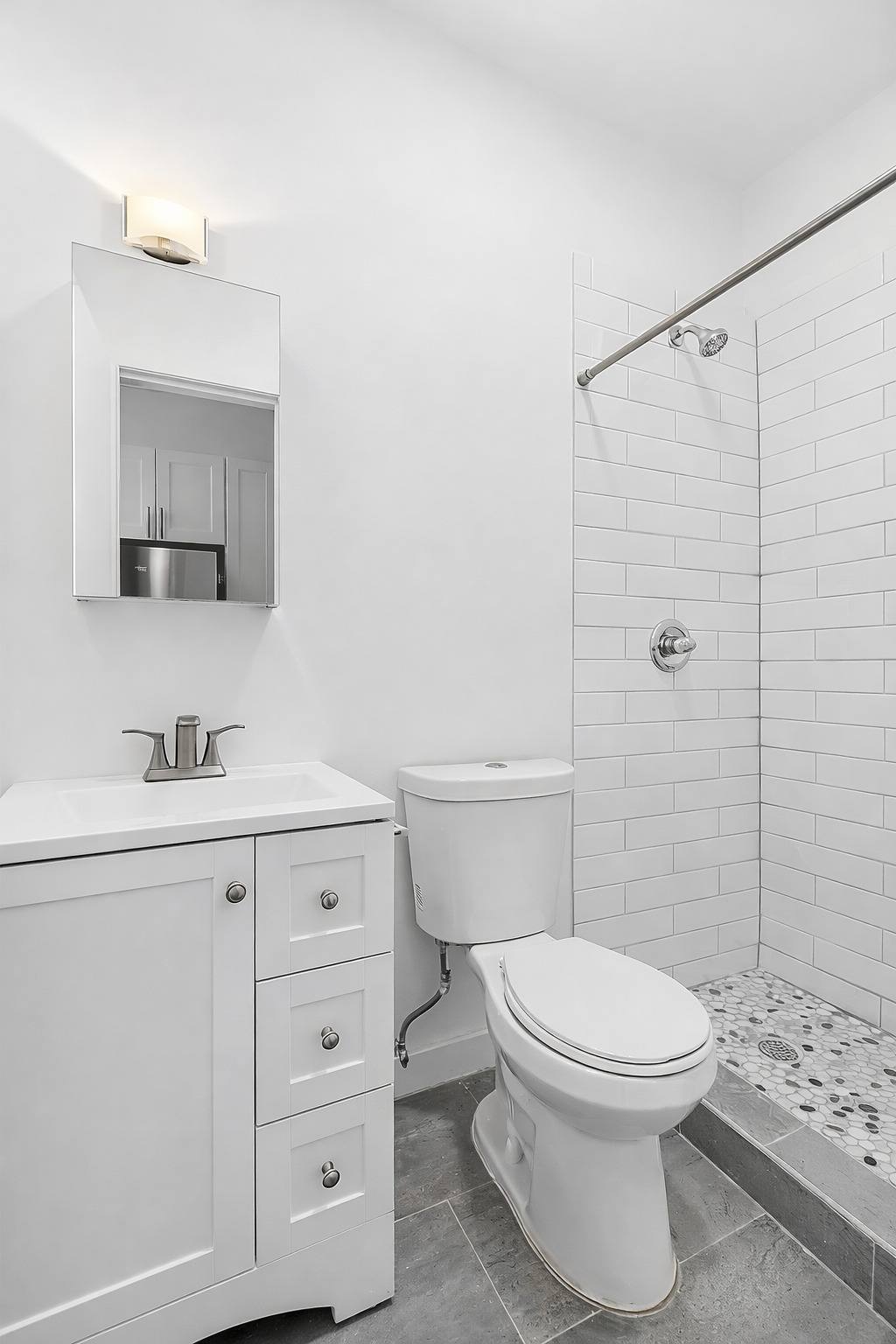 A white bathroom with a toilet, sink, and shower.