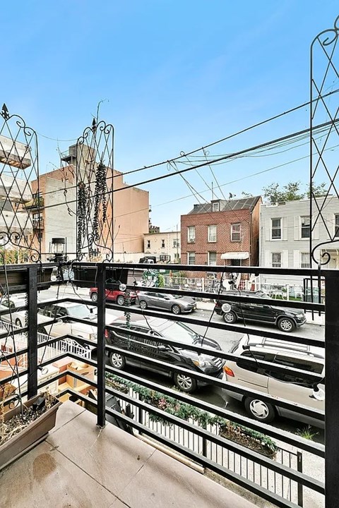 A balcony with a view of a parking lot and buildings.