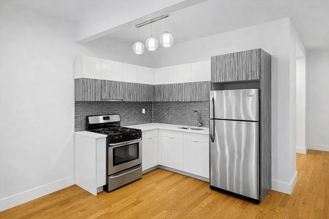 A kitchen with a stove, oven, and refrigerator.