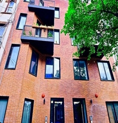 A red brick building with black windows and balconies.