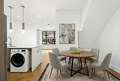 A modern kitchen with a dining table and chairs.