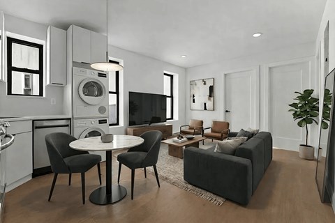 A modern living room with a black sofa, a white table, and a television.