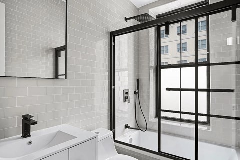 A white bathroom with a black tub and shower.
